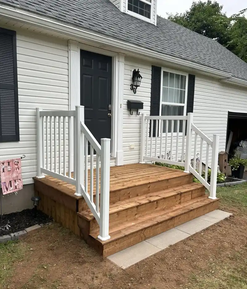 New timber front steps with a white rail against a white house.