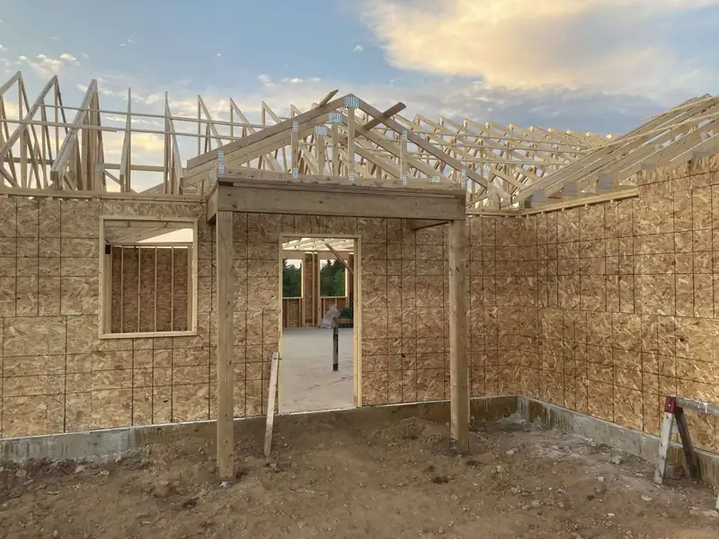 A gable end framed and sheathed, window openings cut, on a new build.