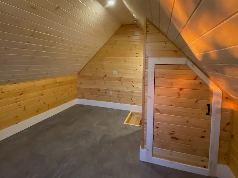 A room lined floor to ceiling in clear pine under a raked ceiling.