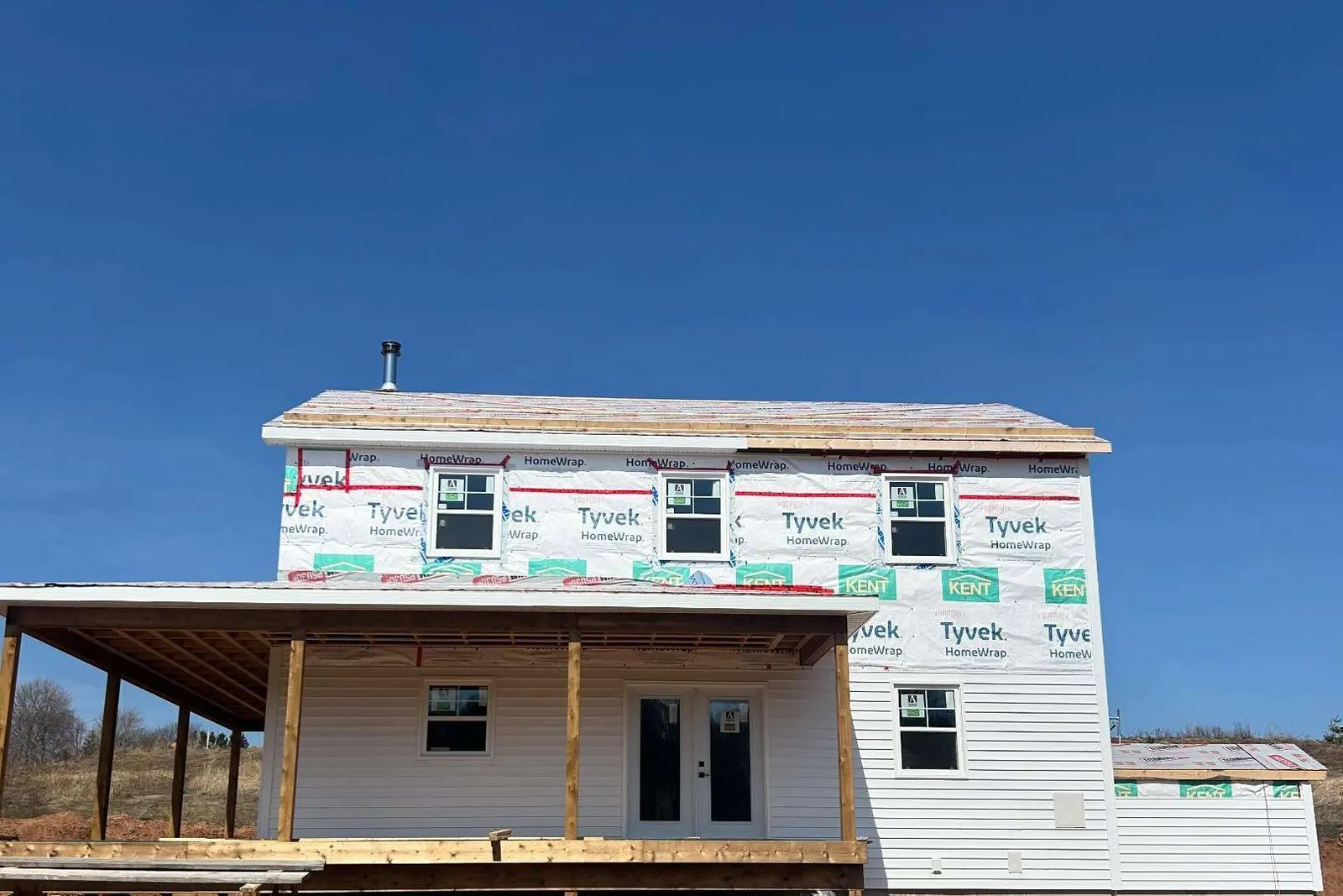 A new two-storey house wrapped and closed in, its verandah framed the length of the front.